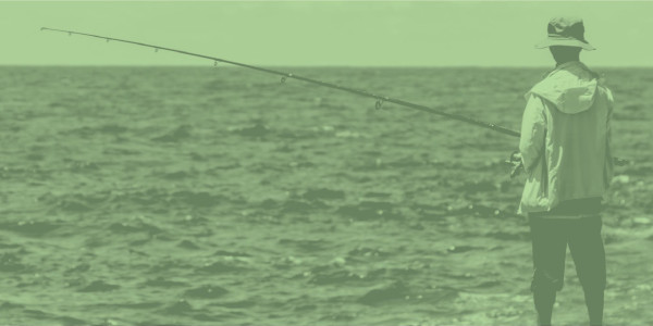 Man phishing in the ocean, overlaid with a color filter in Duo green